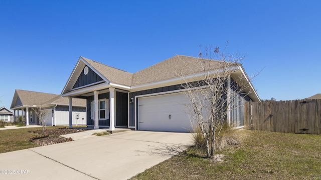 view of front facade featuring board and batten siding, a shingled roof, fence, driveway, and an attached garage