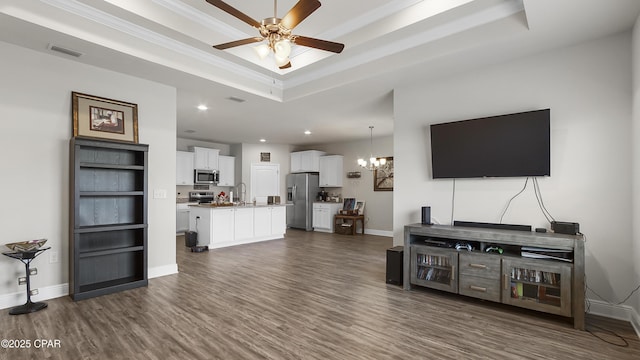 living area with a tray ceiling, baseboards, visible vents, and dark wood-style flooring