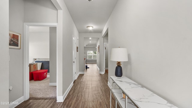 hall with wood finished floors and baseboards