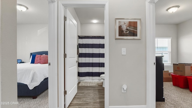 hallway featuring baseboards and wood finished floors