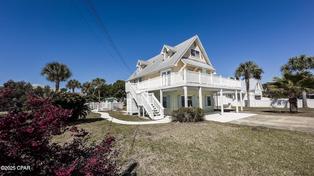 back of property featuring fence, a yard, stairs, a deck, and a patio area