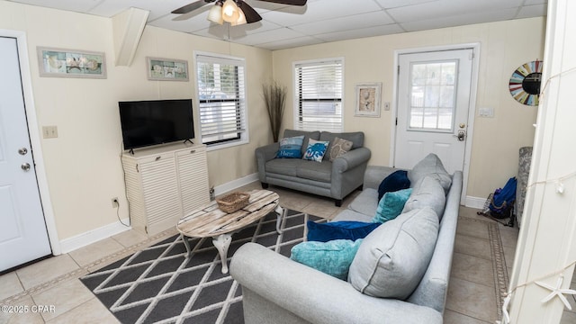 tiled living area with baseboards, a paneled ceiling, and a ceiling fan