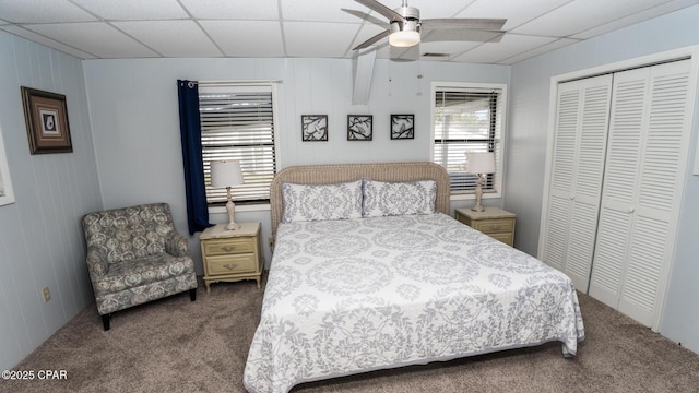 bedroom featuring a ceiling fan, visible vents, carpet, a paneled ceiling, and a closet