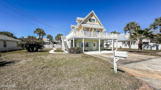 rear view of property with metal roof, stairway, and fence