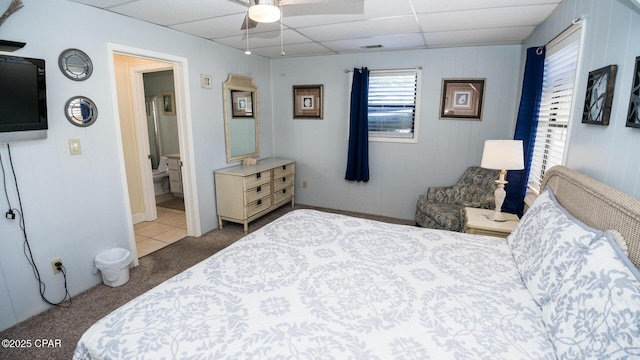 carpeted bedroom featuring a drop ceiling and ceiling fan