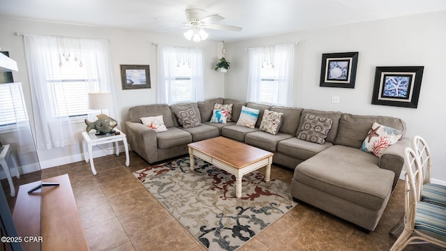 living room featuring a wealth of natural light, tile patterned flooring, baseboards, and ceiling fan