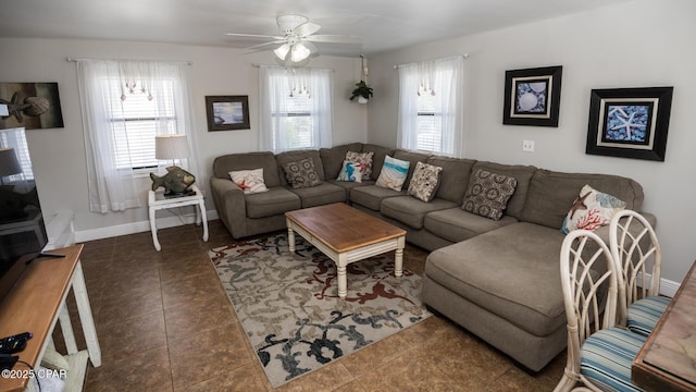 living area with baseboards, ceiling fan, and tile patterned flooring