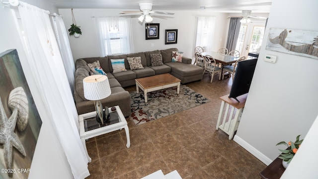 tiled living room featuring a healthy amount of sunlight, baseboards, and ceiling fan