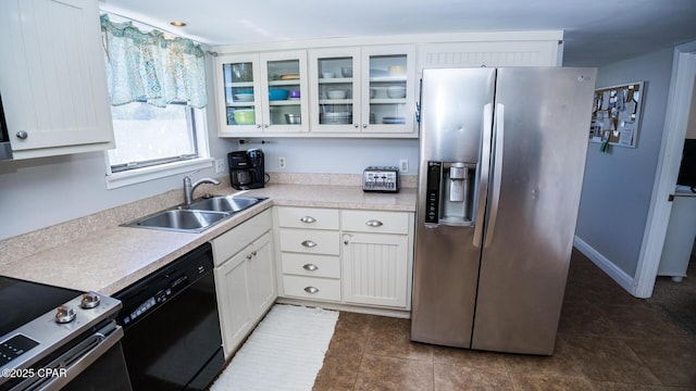 kitchen featuring a sink, stainless steel appliances, light countertops, white cabinets, and glass insert cabinets