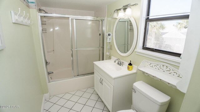 full bathroom with vanity, a healthy amount of sunlight, shower / bath combination with glass door, tile patterned flooring, and toilet