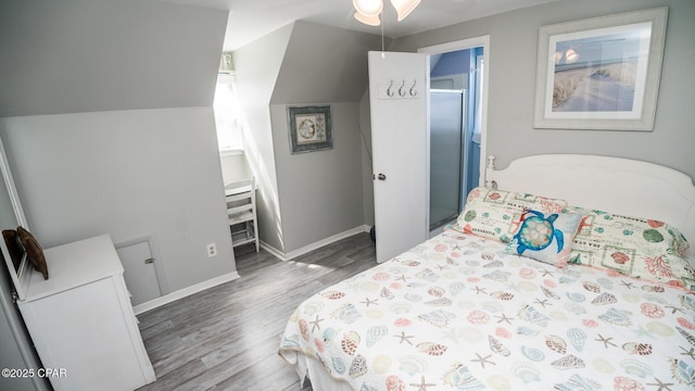 bedroom with baseboards, wood finished floors, and vaulted ceiling