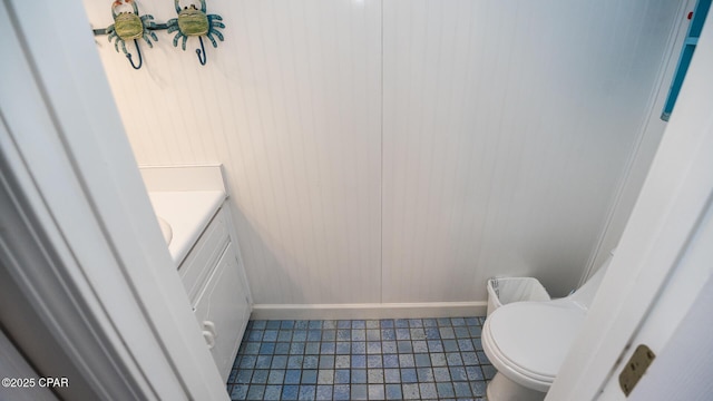 half bath with vanity, toilet, and baseboards