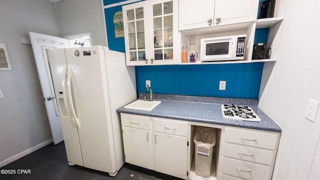 kitchen with white cabinetry, white appliances, glass insert cabinets, and a sink