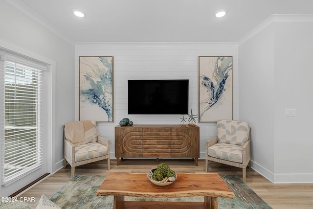 sitting room with ornamental molding, a wealth of natural light, and wood finished floors