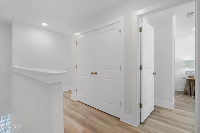 corridor featuring light wood-style flooring, visible vents, baseboards, and recessed lighting