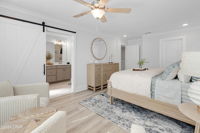 bedroom with a barn door, recessed lighting, light wood-style floors, ornamental molding, and ensuite bath