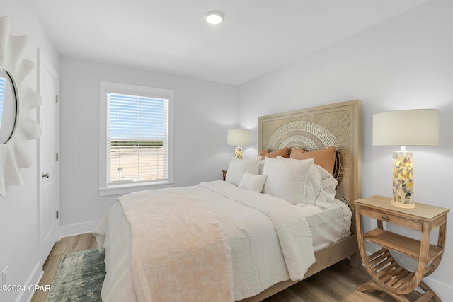 bedroom featuring wood finished floors and baseboards