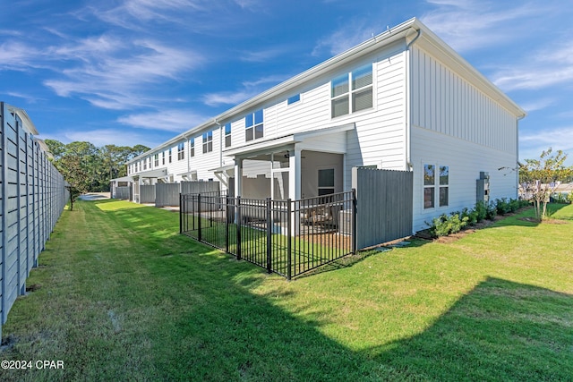 rear view of house featuring a yard, a patio area, and fence