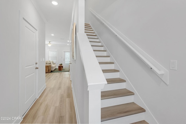 staircase featuring ornamental molding, wood finished floors, and recessed lighting