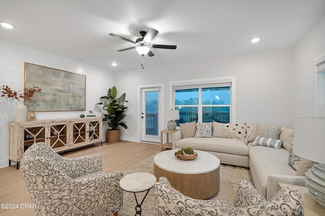 living area featuring recessed lighting, ceiling fan, wooden walls, and wood finished floors