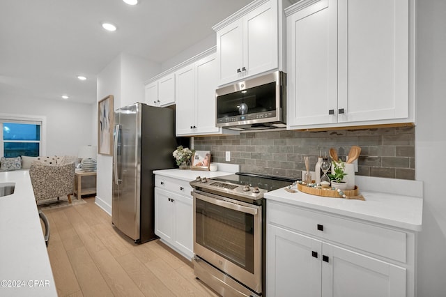 kitchen with light wood-style flooring, white cabinetry, stainless steel appliances, and light countertops