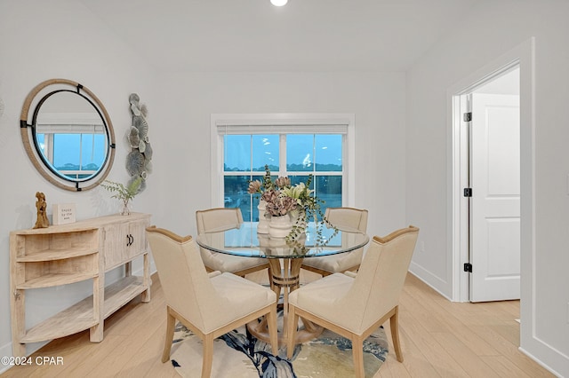 dining space with plenty of natural light, light wood-style flooring, and baseboards