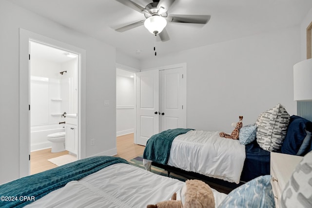 bedroom with baseboards, a ceiling fan, wood finished floors, ensuite bathroom, and a closet