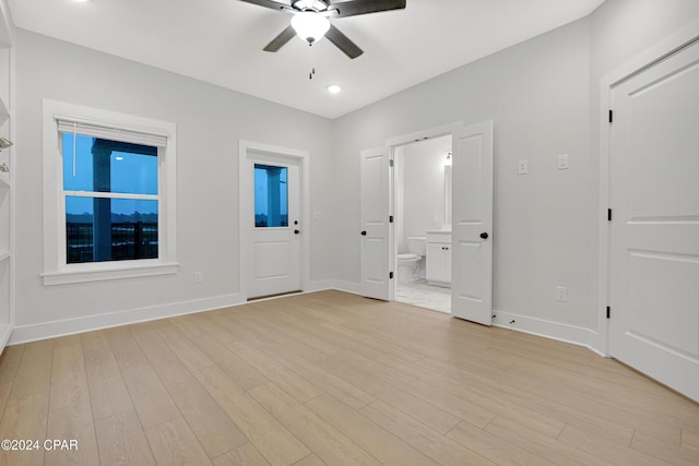 unfurnished room with light wood-style floors, ceiling fan, and baseboards