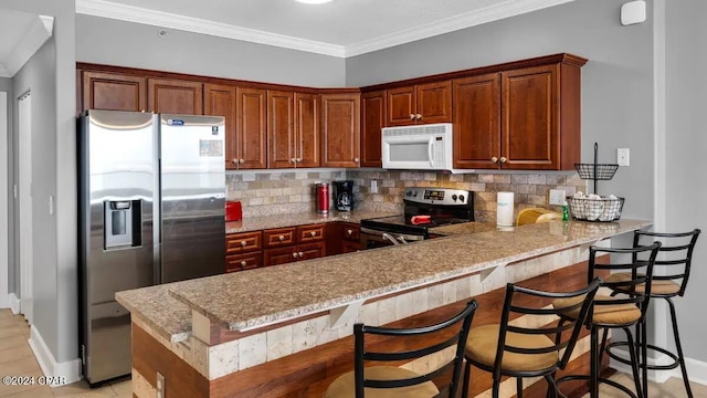 kitchen featuring appliances with stainless steel finishes, a peninsula, backsplash, baseboards, and ornamental molding