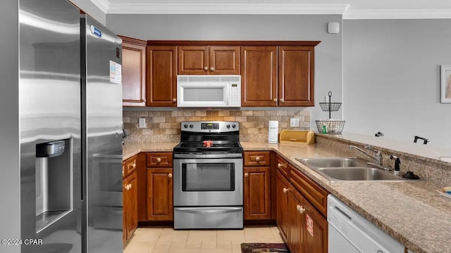 kitchen with appliances with stainless steel finishes, a sink, crown molding, backsplash, and light tile patterned floors