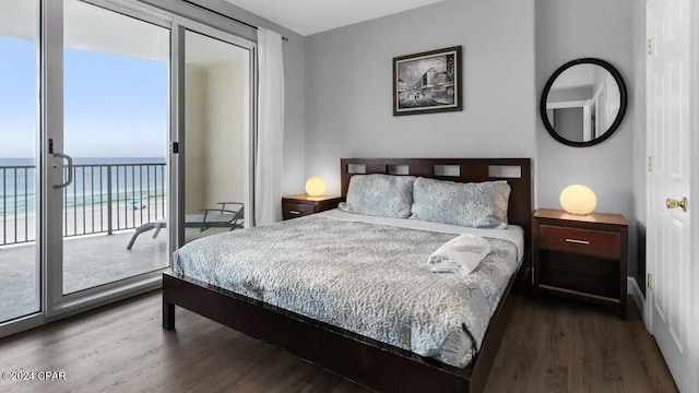 bedroom with wood finished floors, a water view, and access to exterior