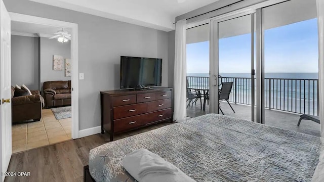 bedroom featuring access to outside, wood finished floors, and baseboards