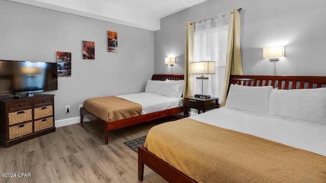 bedroom with wood finished floors and baseboards