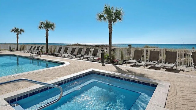 community pool with a community hot tub, a patio, and fence