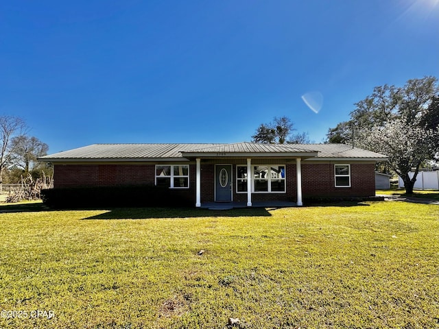 single story home featuring a front yard, brick siding, and metal roof