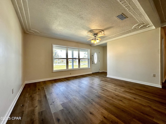 empty room with a textured ceiling, visible vents, dark wood-style flooring, baseboards, and ceiling fan