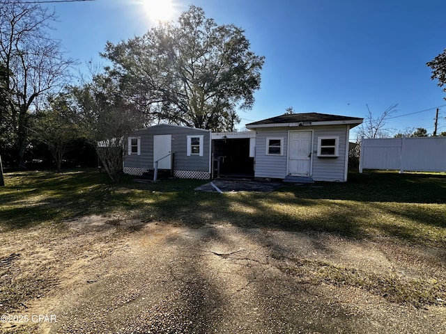 rear view of house with a yard, entry steps, and an outdoor structure