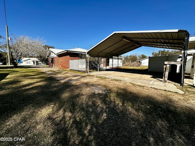 view of yard with a detached carport and driveway