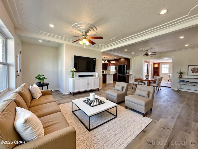 living area with a ceiling fan, baseboards, crown molding, and wood finished floors