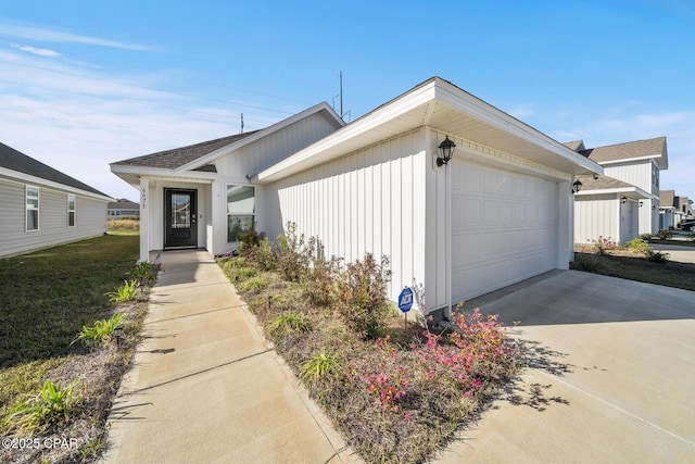 view of front of home with a garage, concrete driveway, and a front yard