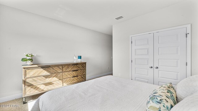 bedroom featuring carpet, a closet, visible vents, and baseboards