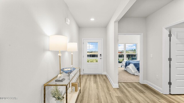 doorway with light wood-type flooring and baseboards