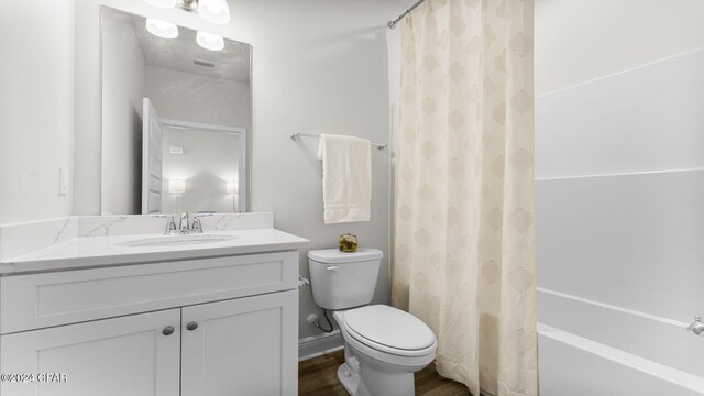 full bath featuring wood finished floors, vanity, toilet, and shower / tub combo with curtain