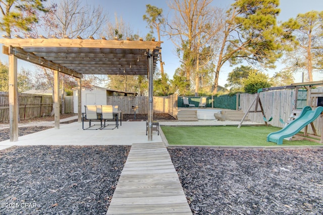 view of yard with an outbuilding, a playground, a shed, a pergola, and a fenced backyard