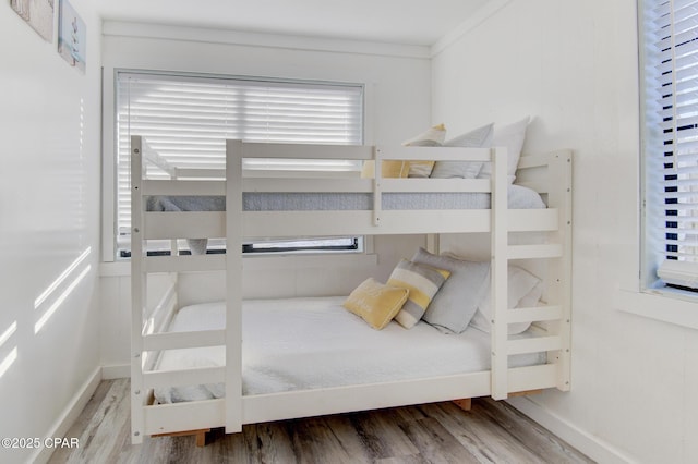 bedroom with baseboards and wood finished floors