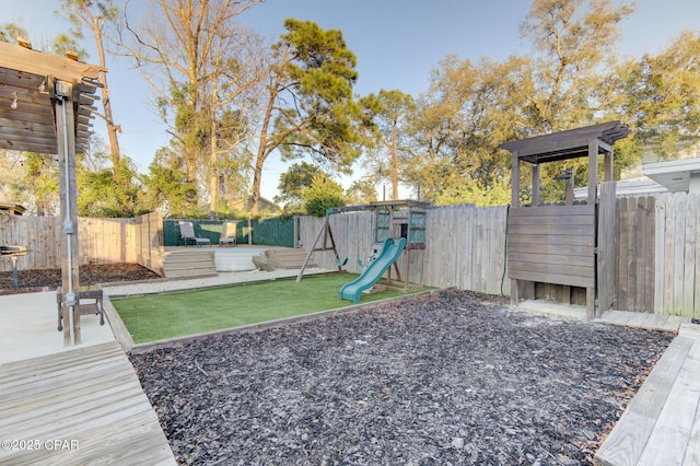 view of yard with a fenced backyard and a playground