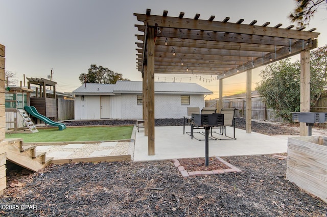 view of patio with a playground, fence, and a pergola