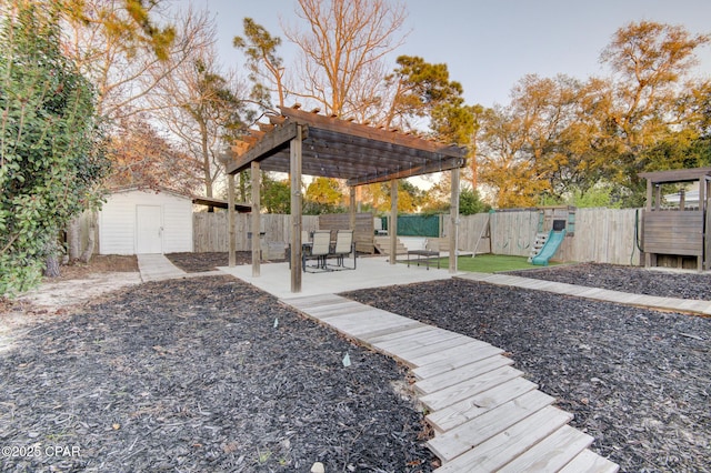 view of yard with a storage shed, a fenced backyard, a pergola, and an outbuilding