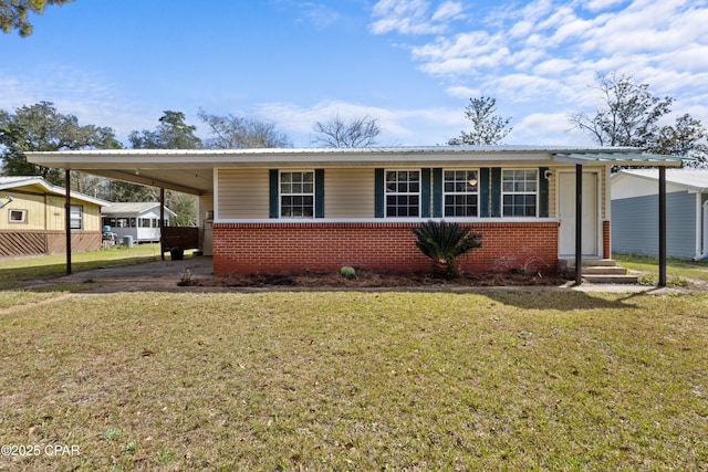 view of front of property featuring entry steps, driveway, a front yard, a carport, and brick siding