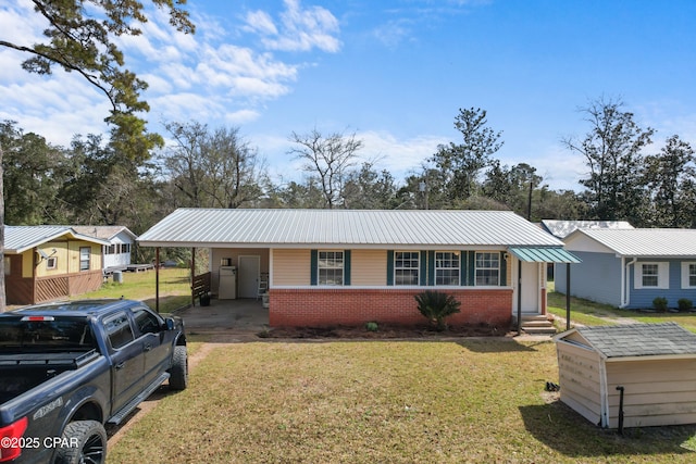 view of front facade featuring entry steps, brick siding, metal roof, and a front lawn